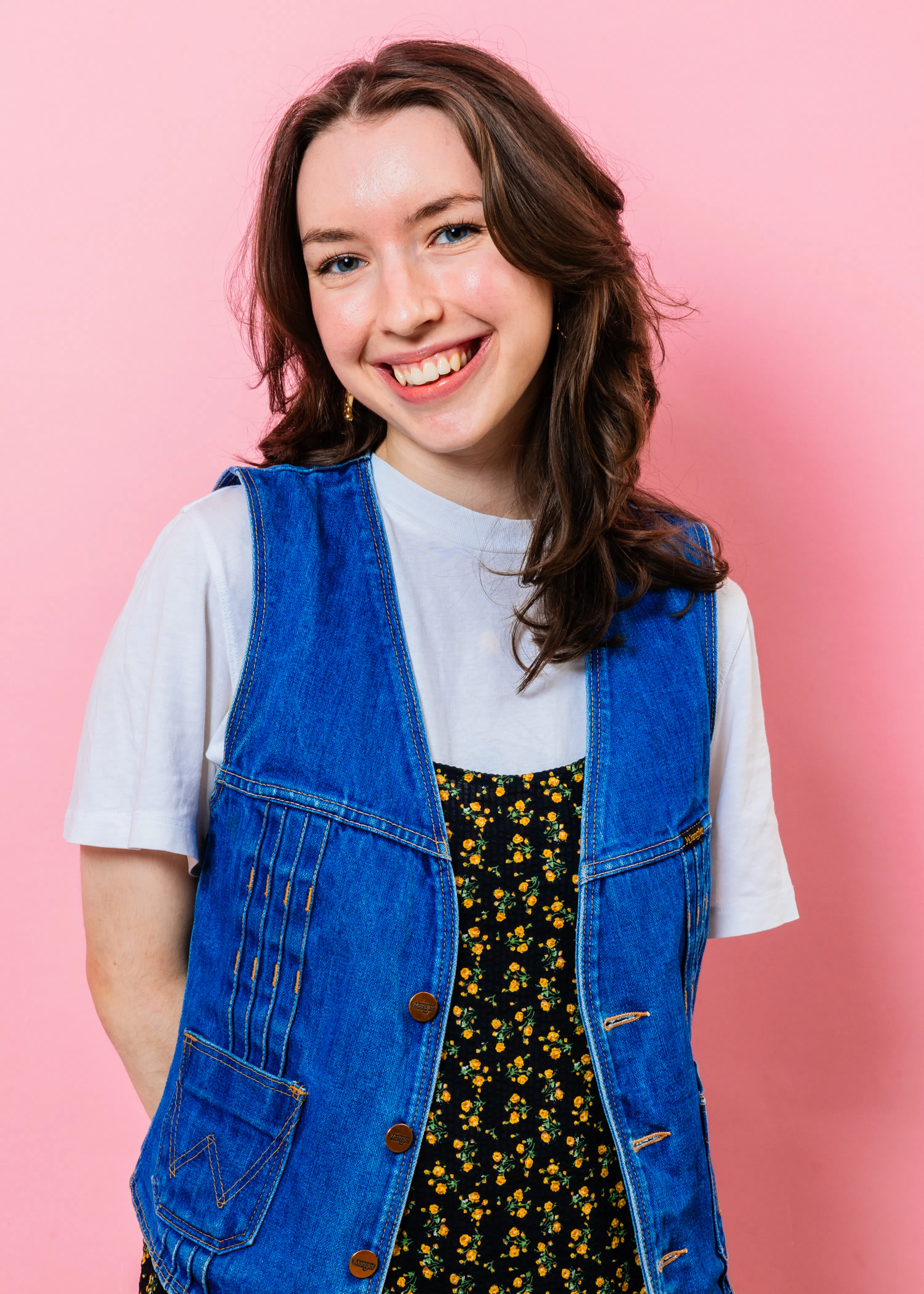 eine frau lächelt und trägt eine jeansweste und ein weißes t-shirt